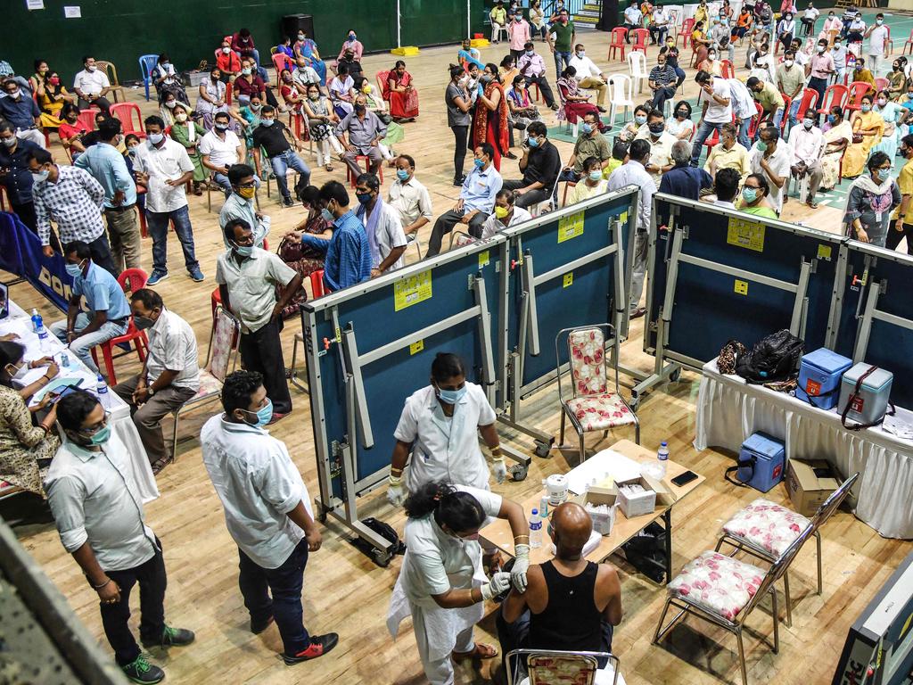 A medical worker inoculates a man with a dose of the coronavirus vaccine at an indoor stadium in Guwahati, India. Picture: AFP