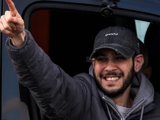 TOPSHOT - Newly-released Israeli hostage Eliya Cohen gestures as he arrives in a vehicle at Beilinson Hospital in the Rabin Medical Centre in Petah Tikva in central Israel on February 22, 2025. Three more Israeli hostages were freed by Hamas militants at a ceremony in central Gaza on February 22 after two others were released in the southern part of the Palestinian territory. (Photo by AHMAD GHARABLI / AFP)