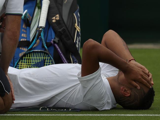 Australia's Nick Kyrgios receives treatment at the end of the second set, before retiring from his men's singles first round match against France's Pierre-Hughes Herbert.