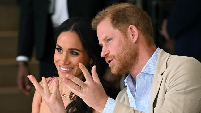 Britain's Prince Harry (R), Duke of Sussex, speaks with his wife Meghan Markle while attending a show during a visit to the National Centre for the Arts in Bogota on August 15, 2024. Prince Harry and his wife, American actress Meghan Markle, arrived in Colombia at the invitation of vice President Francia Marquez, with whom they will attend various meetings with women and young people to reject discrimination and cyberbullying. (Photo by RAUL ARBOLEDA / AFP)