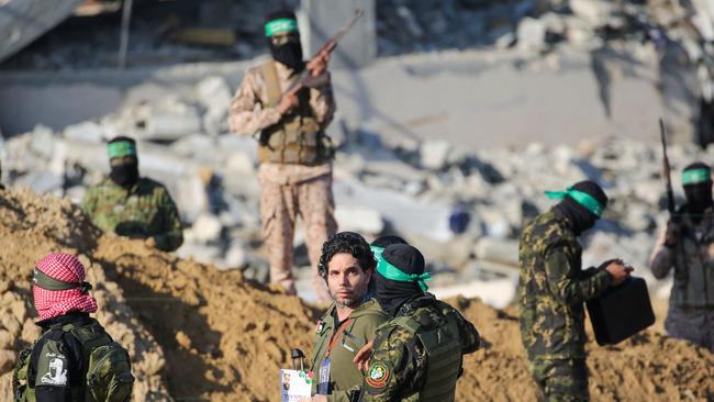 Palestinian militant group Hamas fighters escort Israeli-French hostage Ofer Kalderon before handing him over to a Red Cross team in Khan Younis for transfer to Israeli authorities on Saturday as part of fourth hostage-prisoner exchange. Picture: Eyad Baba / AFP