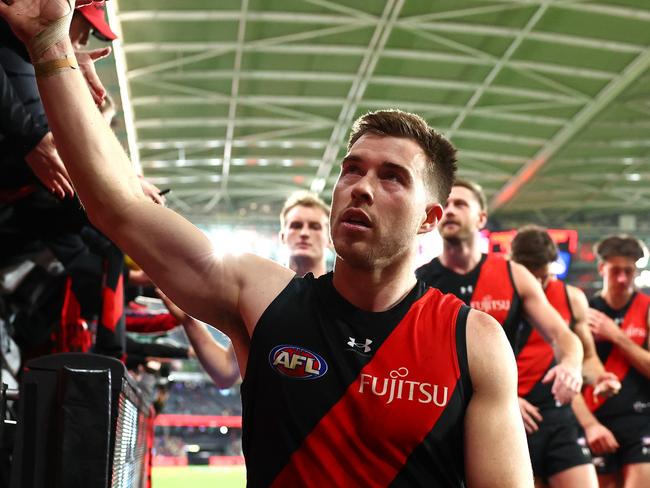 MELBOURNE, AUSTRALIA - JUNE 23: Zach Merrett of the Bombers high fives fans after winning the round 15 AFL match between Essendon Bombers and West Coast Eagles at Marvel Stadium, on June 23, 2024, in Melbourne, Australia. (Photo by Quinn Rooney/Getty Images)