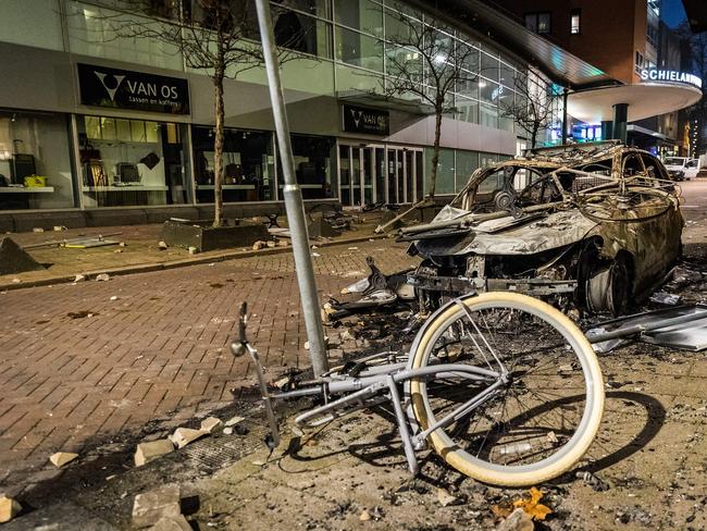 Dutch police fired warning shots, injuring at least two people, after rioters against a partial Covid lockdown torched a police car and hurled stones in Rotterdam. Picture: AFP