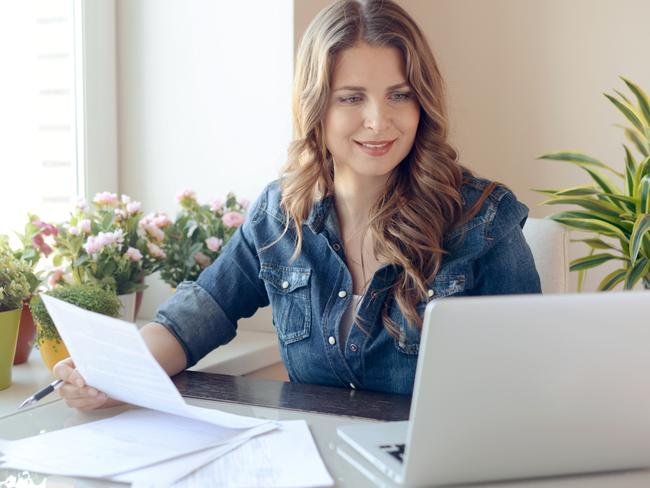 Young beautiful woman sitting at the table and working at home istock image