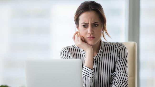 Confused businesswoman annoyed by online problem, spam email or fake internet news looking at laptop, female office worker feeling shocked about stuck computer, bewildered by scam message or virus