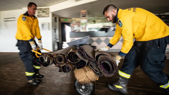 Hobbity RFS members removing saturated and ruined carpet at The Camden Sports Club, which would be a breeding ground for mould. Picture: Julian Andrews.