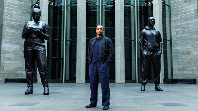 British artist Thomas J. Price with his sculptures Reaching Out (left) and All In, at the National Gallery of Victoria for the NGV Triennial. Picture: Aaron Francis