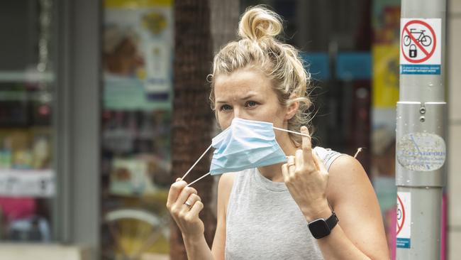 A shopper removes her mask after leaving a supermarket in Manly. Picture: Jenny Evans/Getty Images