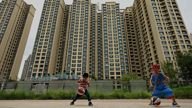 Children play basketball in front of a housing complex by Chinese property developer Evergrande in Beijing. Picture: AFP