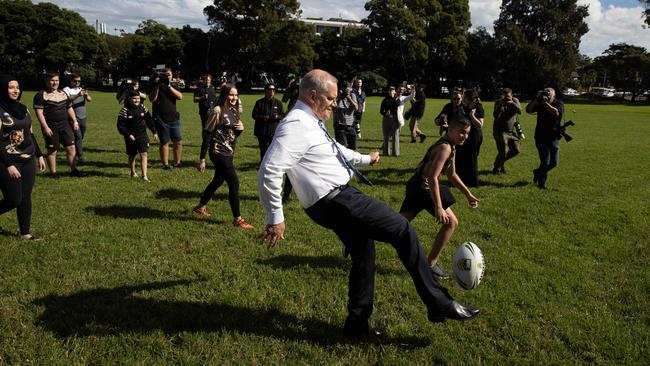 Morrison kicks a footy on the campaign trail in Sydney. Picture: Jason Edwards