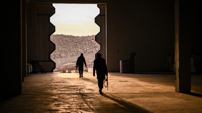 Syrian rebel fighters search the warehouse of a factory that contained the entire chain of Captagon production, in Douma, on the eastern outskirts of Damascus. Picture: AFP