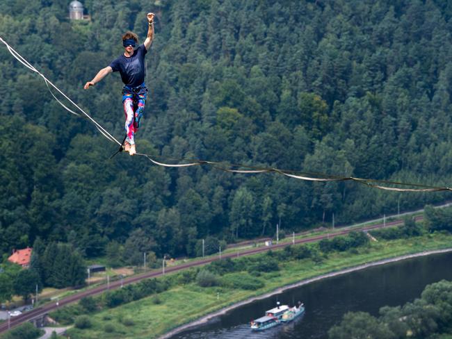 Slackliner Kai is blindfolded as he walks on a highline over the river Elbe at the Koenigstein Fortress in Koenigstein near Dresden, eastern Germany, during an outdoor and trend sports festival. Picture: AFP