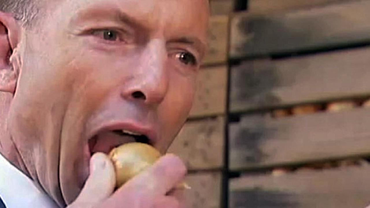 Tony Abbott eating an onion during a visit to Charlton Farm Produce at Moriarty.