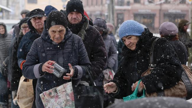 Elderly people receive food and gloves from a charity organisation in a snow-covered street in Kyiv after recent waves of Russian missile and drone strikes left them without power. Picture: Getty Images