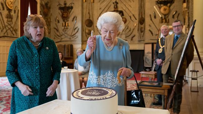 The Queen cuts a cake to celebrate the start of the platinum jubilee during a reception in the ballroom of Sandringham House. Picture: Getty