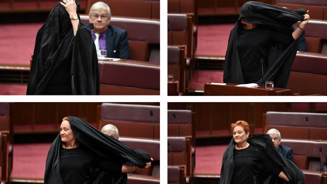 One Nation Senator Pauline Hanson taking off a burqa at Parliament House. Picture: AAP Image/Lukas Coch.