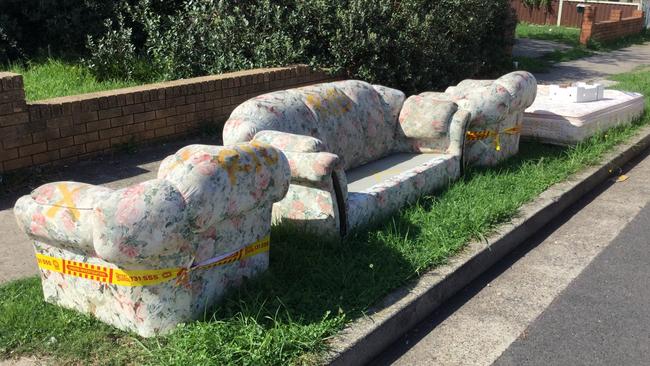 Couches and a mattress line are discarded on an Auburn street.