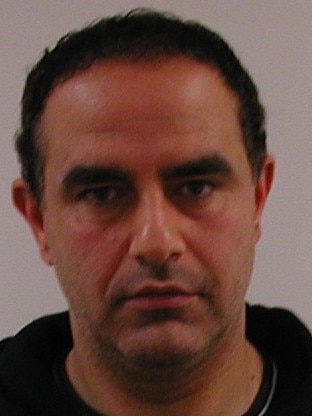 A police mugshot of Karam.