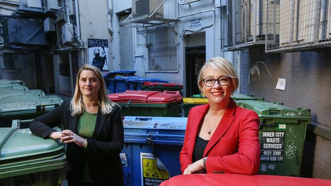 Cr Cathy Oke with Lord Mayor Sally Capp amid bins in a city laneway. Picture: Ian Currie