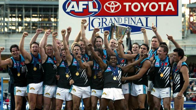 Power team footballers on podium after being presented premiership medals and trophy cup after win. AFL football - Brisbane Lions vs Port Adelaide Power grand final match at MCG 25 Sep 2004.