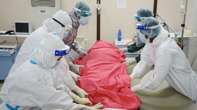 Medical staff wrap the body of 72-year-old patient who just passed away due to COVID-19 at the Intensive Care Unit of the makeshift hospital installed inside Millennium Hall in Addis Ababa, Ethiopia. Picture: AFP