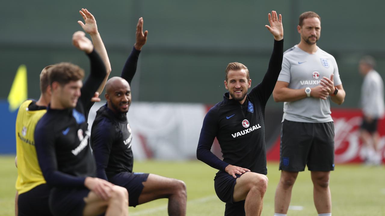 England's Harry Kane (R) stretches with teammates.