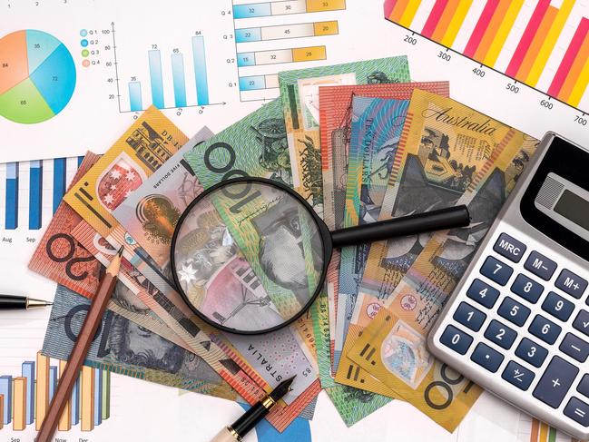 Business graphs with australian dollars, magnifier, pen and calculator Australian money tax generic