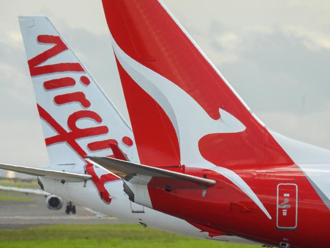 The vertical stabilisers of a Qantas Boeing B737-838 plane, registration VH-VZQ, and a Virgin Australia Boeing B737-8FE plane, registration VH-VUZ, waiting at the northern end of the main runway of Sydney Kingsford-Smith Airport in preparation for departure.  The Qantas plane is heading to Adelaide as flight QF741 and the Virgin plane is heading to Adelaide as flight VA428.  In the background is another Virgin B737-8FE plane. This image was taken from Nigel Love Bridge, Mascot on a sunny afternoon on 3 December 2023.Escape 9 February 2025Cover storyPhoto - iStock