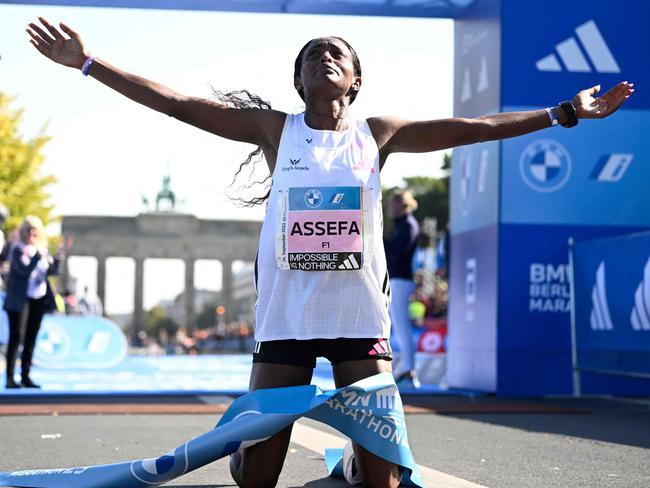 Ethiopia's Tigist Assefa celebrates after smashing the women's marathon world record by crossing the finish line to win the women's race of the Berlin Marathon on September 24, 2023 in Berlin, Germany. (Photo by Tobias SCHWARZ / AFP)