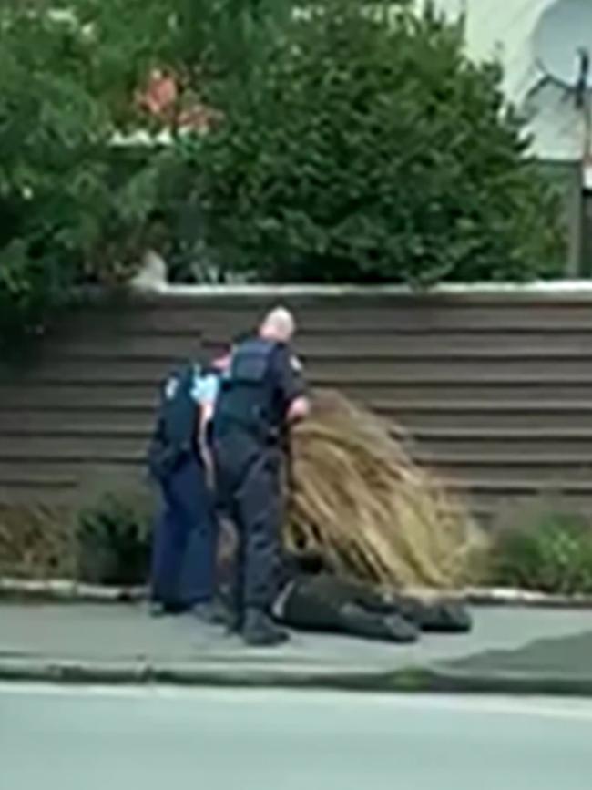 Police hold a suspect to the ground following the shooting. Picture: Mary Outram 