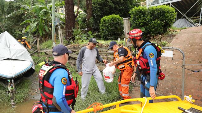 An SES Crew out near Wisemans Ferry on Saturday deliver supplies to Mark Hollen, a resident cut off by floodwaters on the Hawkesbury River. Picture: Tim Hunter