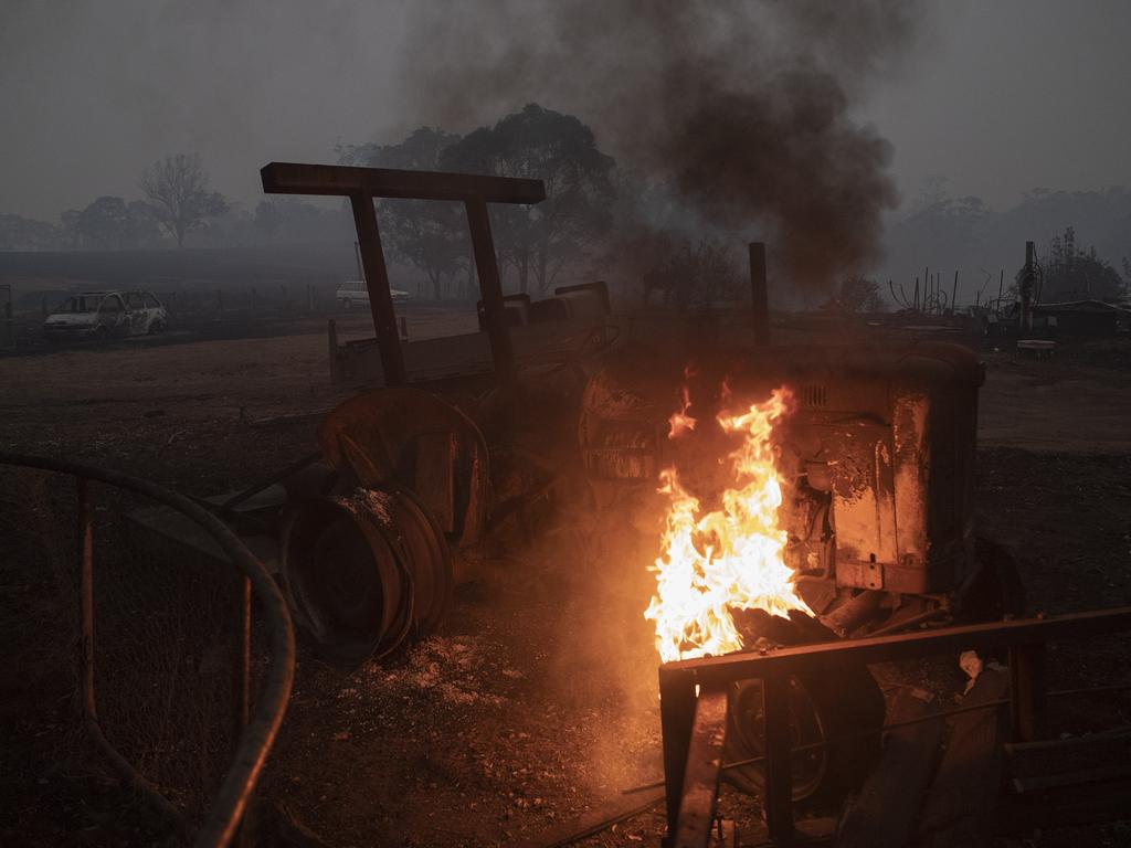 The morning after a devastating blaze destroyed homes and businesses in the small town of Cobargo. The town has been decimated by fire. A tractor still on fire in the backyard of a destroyed property. Picture Gary Ramage