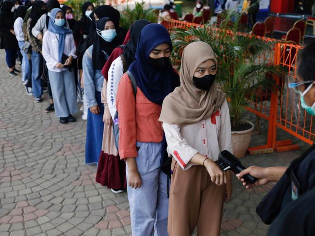 A girl has her temperature checked during a mass vaccination program. Picture: Reuters/Willy Kurniawan