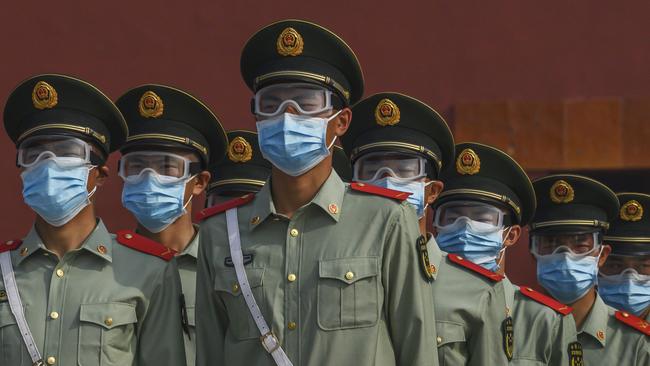 Chinese paramilitary police wear protective masks as they guard the entrance to the Forbidden City in Beijing on May 2. Picture: Getty Images