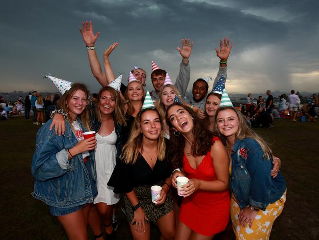New Years Eve 2018 - 9pm Fireworks display from Dudley Page Reserve in Dover Height. Friends front L-R Ebony Scott (black top), Mali Eber-Rose (red dress) and Paige Challans (yellow dress) party with friends. Picture: Toby Zerna