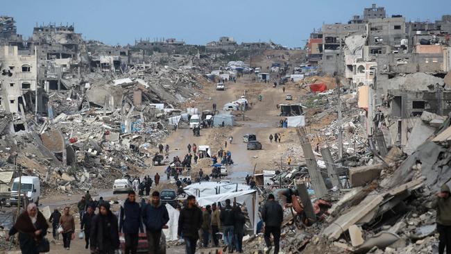 Displaced Palestinians walk through a muddy road amid the destruction in Jabalia in the northern Gaza Strip. Picture: AFP