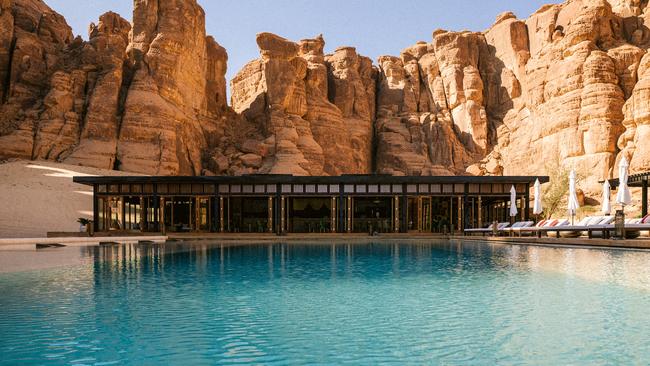 The pool at Al-Ula in Saudi Arabia set against sandstone cliffs.