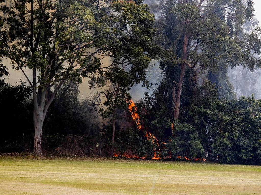 Smoke haze covers the Gold Coast Skyline from a grass fire at Carrara. Emergency services at St Michael's Collage, Merrimac. Fire burning near the school oval. Picture: Jerad Williams