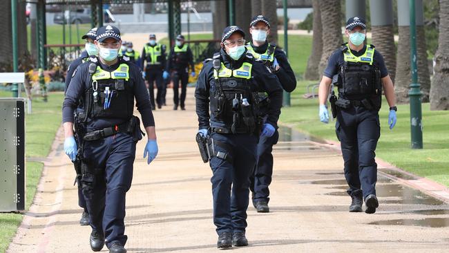 A large number of police keep an eye on Catani Gardens in St Kilda for anti-lockdown protesters. Picture: David Crosling