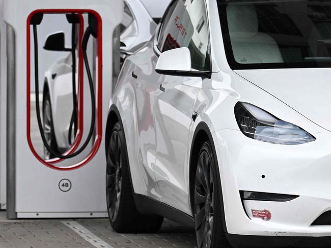 A Tesla electric vehicle charges at a Tesla Supercharger location in Santa Monica, California on May 15, 2024. After laying off hundreds of employees on Teslaâs Supercharging team, Elon Musk posted on X that Tesla will spend over $500M expanding the Supercharger network. (Photo by Patrick T. Fallon / AFP)