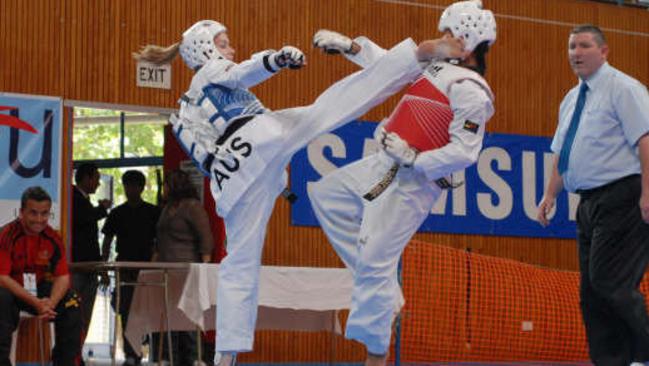 Cassie (in blue) executing a roundhouse kick to her opponent’s head.