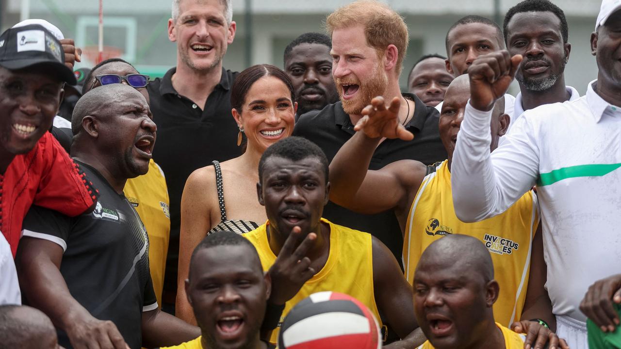 Harry and Meghan pictured last week with volleyball players at Nigeria Unconquered, a local charity organisation that supports wounded, injured, or sick service members. Picture: Kola Sulaimon / AFP