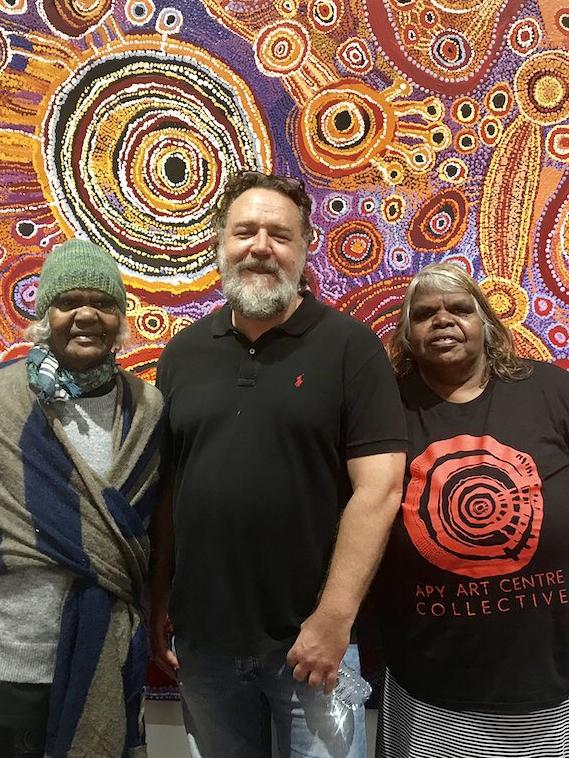 Russell Crowe visits Tjala Arts in South Australia in 2017. There is no suggestion the art in this picture has been interfered with. Picture: Supplied