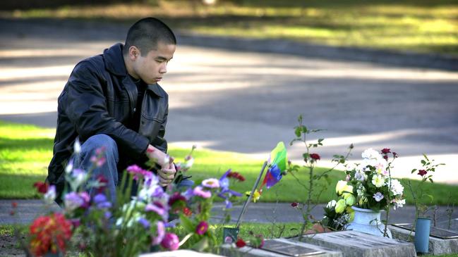 Gonzales is pictured at the grave of his parents Mary Loiva and Teddy and sister Clodine. File picture