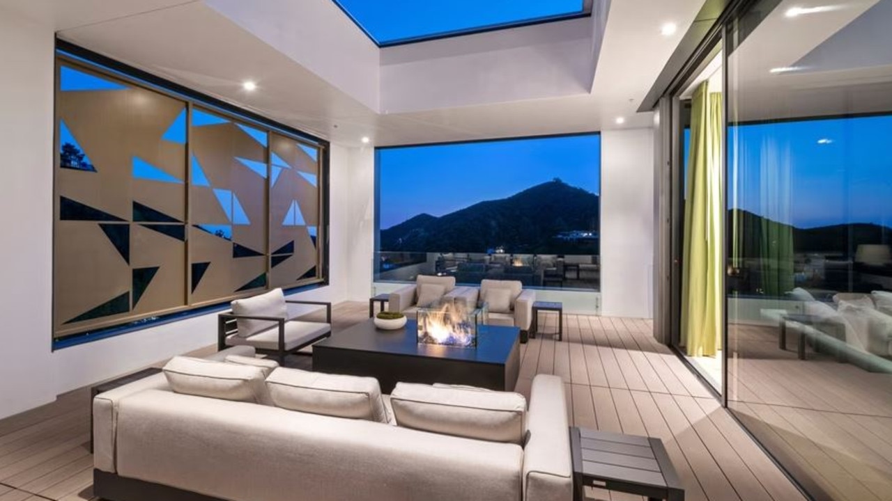 The living room and chef's kitchen are separated by half of a wall, which comes with a mini fire pit. Picture: Marc Angeles via Realtor