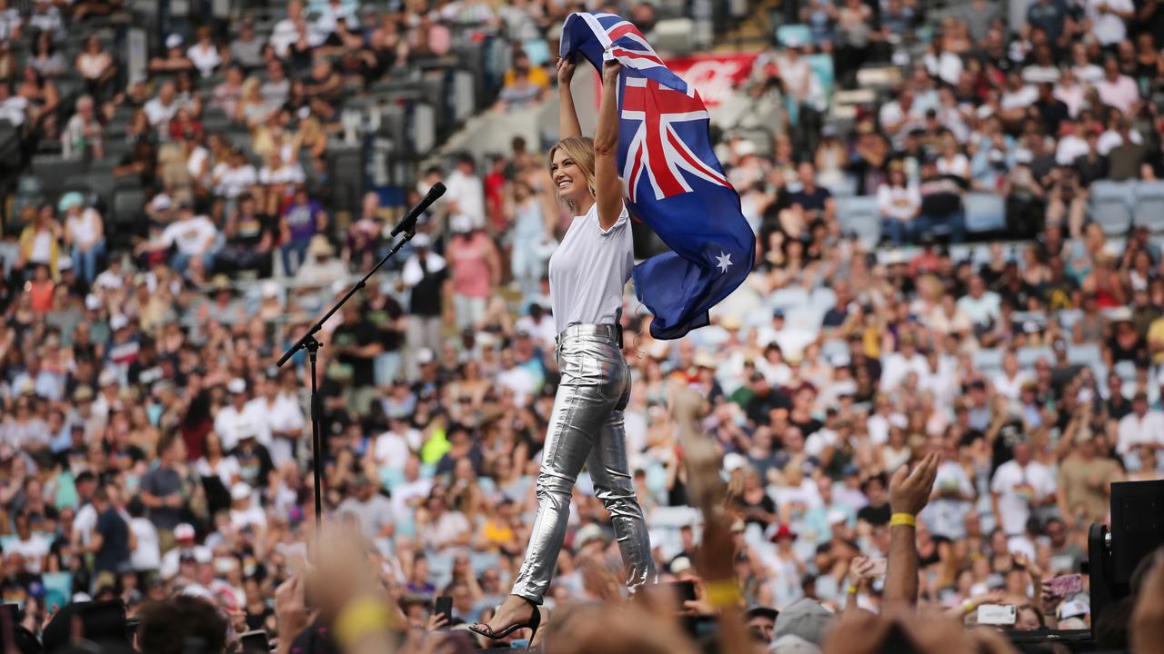 Delta Goodrem holds up the Australian flag. Picture: Richard Dobson