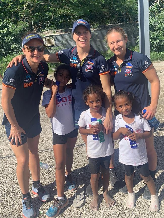 Crows AFLW players Angela Foley (L), co-captain Chelsea Randall and Nikki Gore with Nauruan children in Nauru. Picture: Supplied, Adelaide Crows