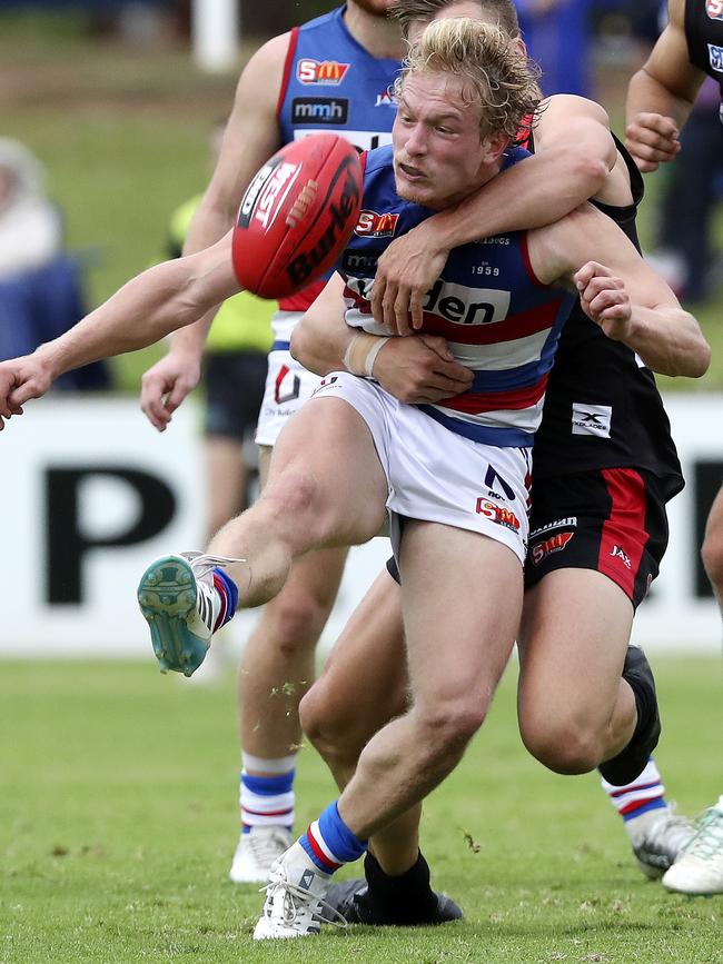 Central District’s Travis Schiller attempts to get his kick away under pressure against West Adelaide. Picture: Sarah Reed