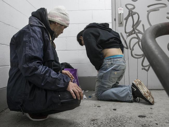 Vinny looks on as his friend starts to feel the effects after injecting heroin in a stairwell within the carpark. Picture: Ian Currie