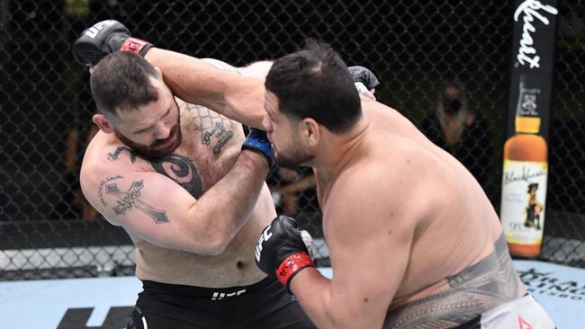 LAS VEGAS, NEVADA – MARCH 20: (R-L) Tai Tuivasa of Australia punches Harry Hunsucker in their heavyweight fight during the UFC Fight Night event at UFC APEX on March 20, 2021 in Las Vegas, Nevada. (Photo by Chris Unger/Zuffa LLC via Getty Images)